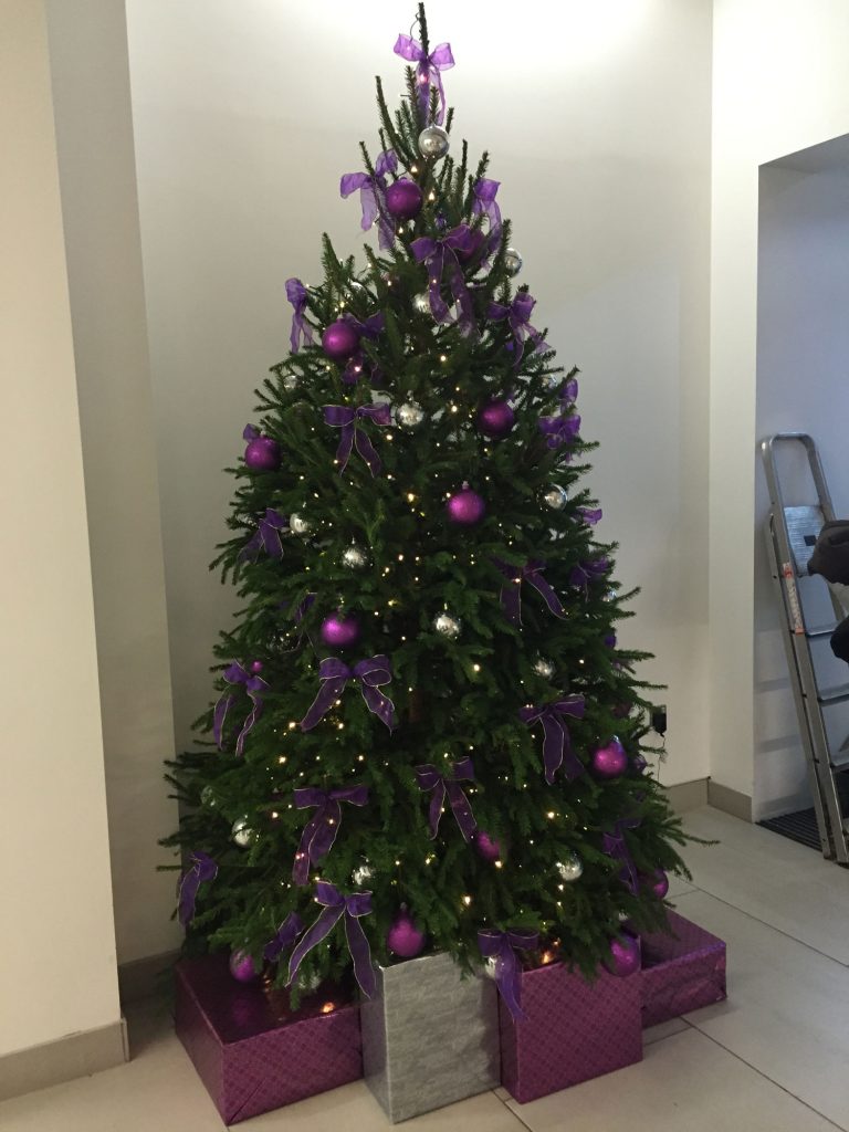 Christmas tree with purple bows, decorations and presents